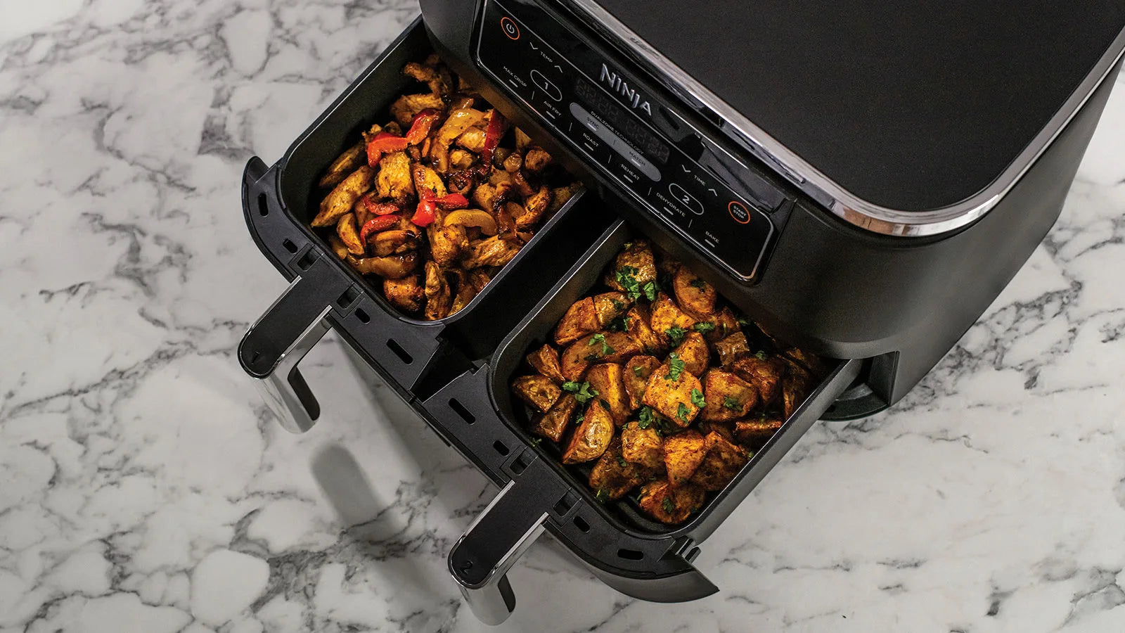 Ninja Foodi Dual Zone Airfryer AF300EU bereidt twee gerechten tegelijkertijd in aparte kookzones – dubbele airfryer met gescheiden lades voor gelijktijdig koken.